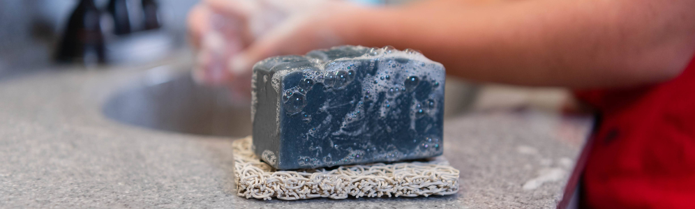 Washing hands with charcoal goat milk soap