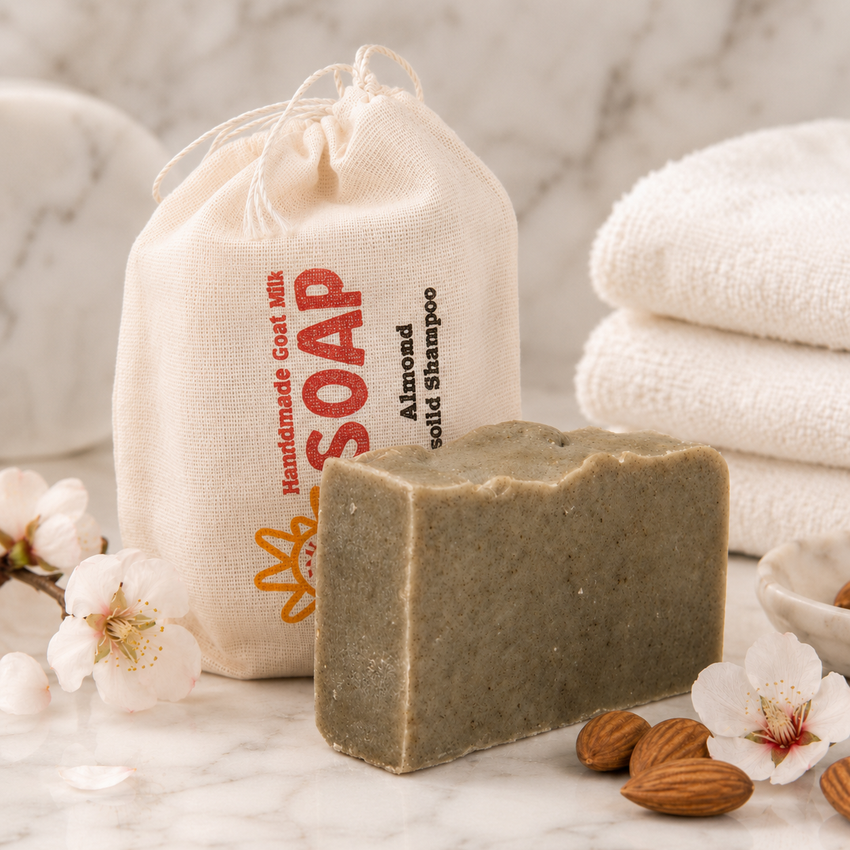Bar of shampoo soap with a drawstring bag labeled 'Handmade Goat Milk Soap' on a marble surface.