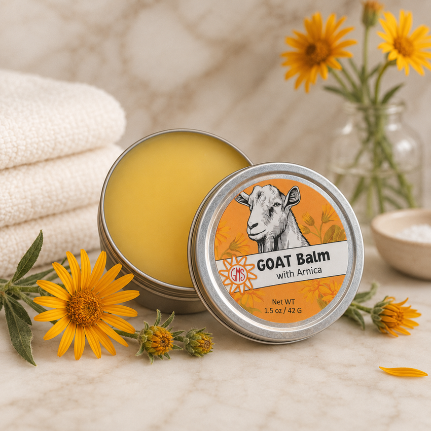 Goat balm tin with Arnica on a wooden surface with flowers and towels in the background