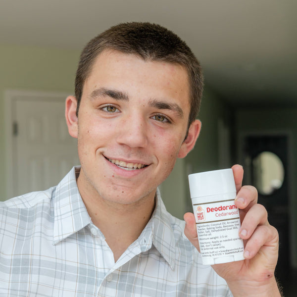 Man holding a container of Goat Milk Stuff Deodorant