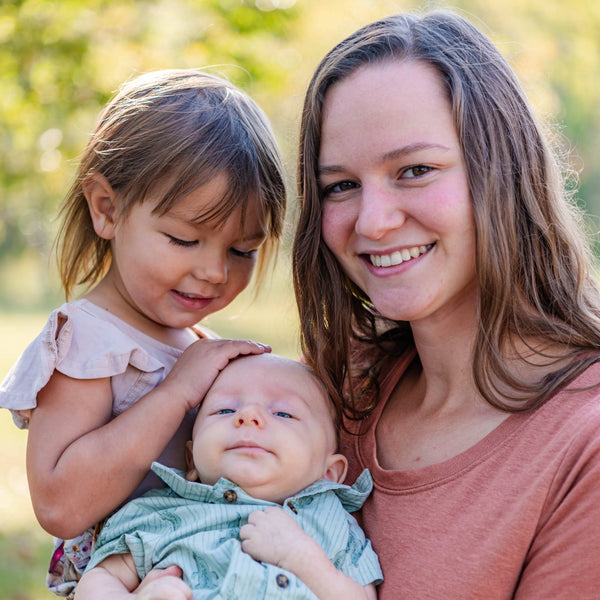 Woman holding a baby and young girl