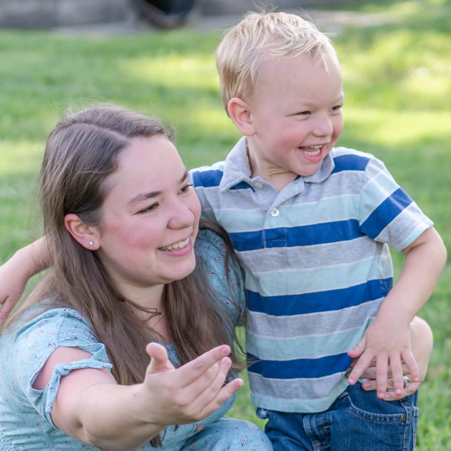 Woman and child sitting on grass in a park