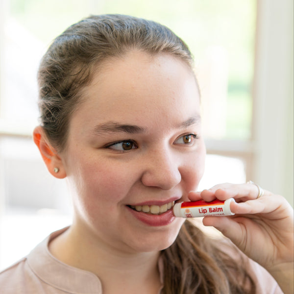 Woman applying a Goat Milk Stuff lip balm
