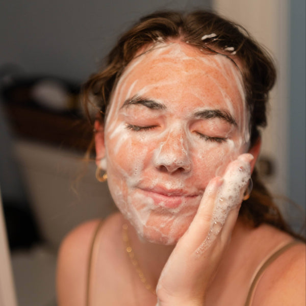 Woman washing her face with soap suds