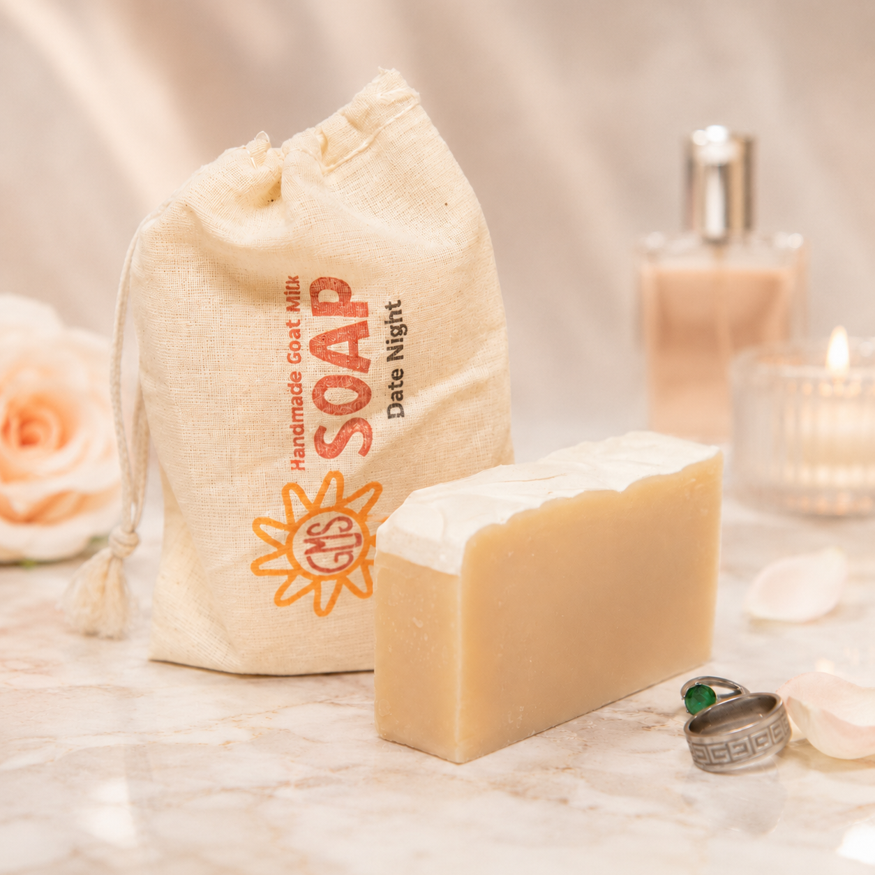 Bar of goat milk soap with a drawstring bag labeled 'Handmade Goat Milk Soap' on a soft surface.