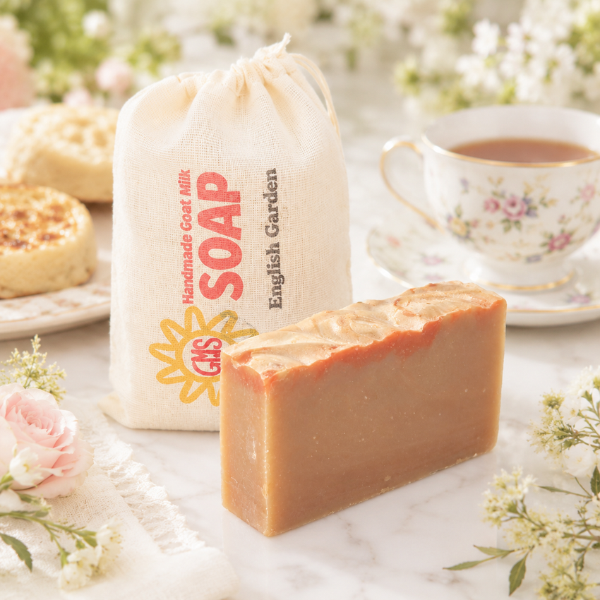 Bar of goat milk soap with a drawstring bag labeled 'Soap' and a cup of tea on a marble surface.