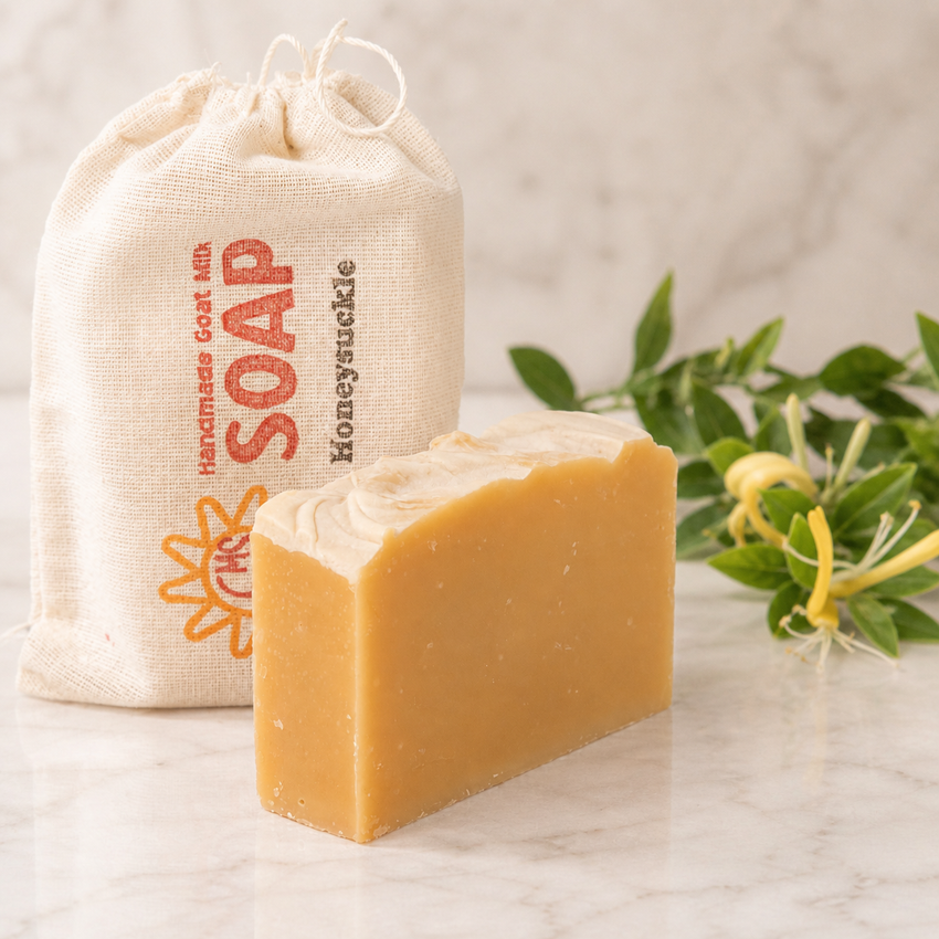 Bar of goat milk soap with a drawstring bag labeled 'Soap' on a marble surface.
