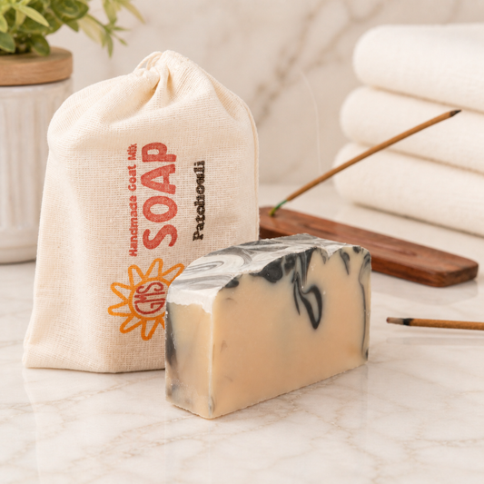 Marble-patterned goat milk soap bar with a drawstring bag labeled 'Soap' on a marble surface.
