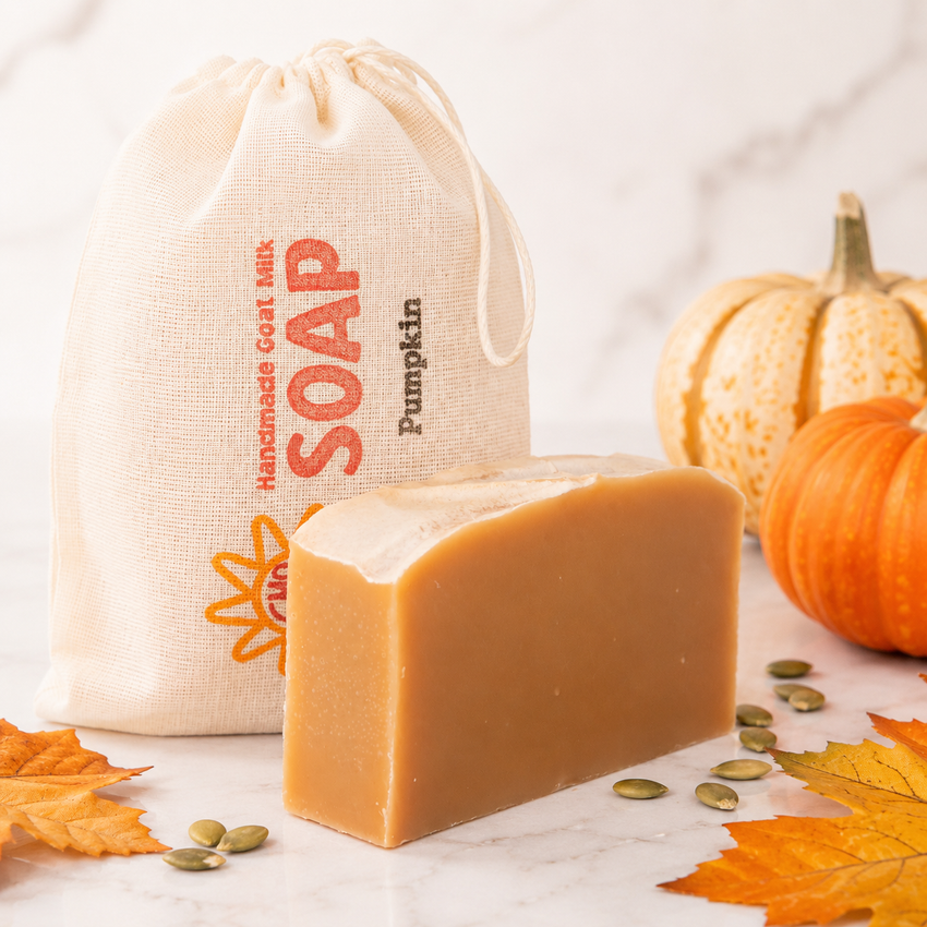 Bar of goat milk soap with a pumpkin-themed drawstring bag on a white background