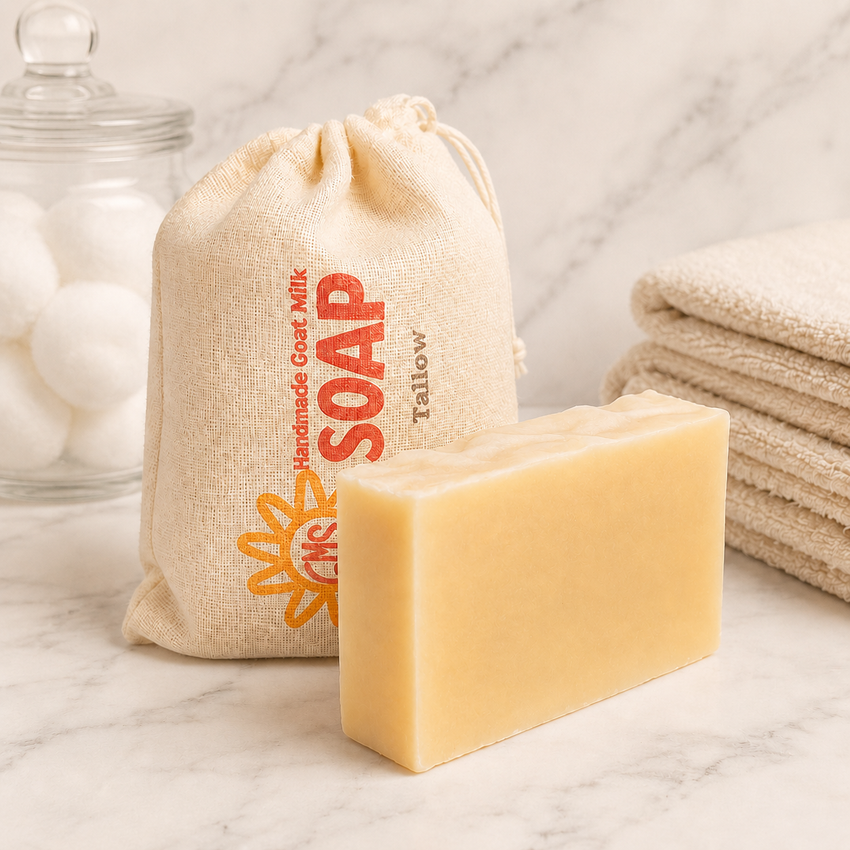 Bar of Tallow goat milk soap with a drawstring bag labeled 'Soap' on a marble surface.