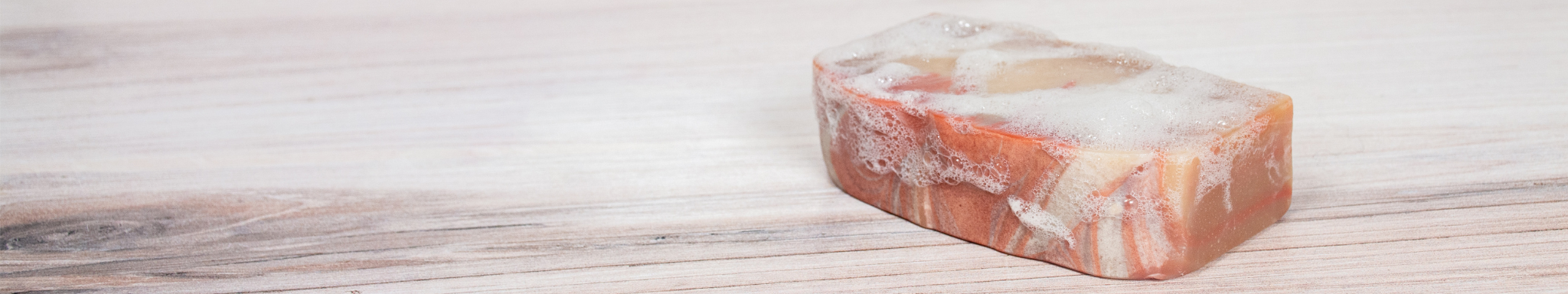 back ground with goat milk soap covered in suds