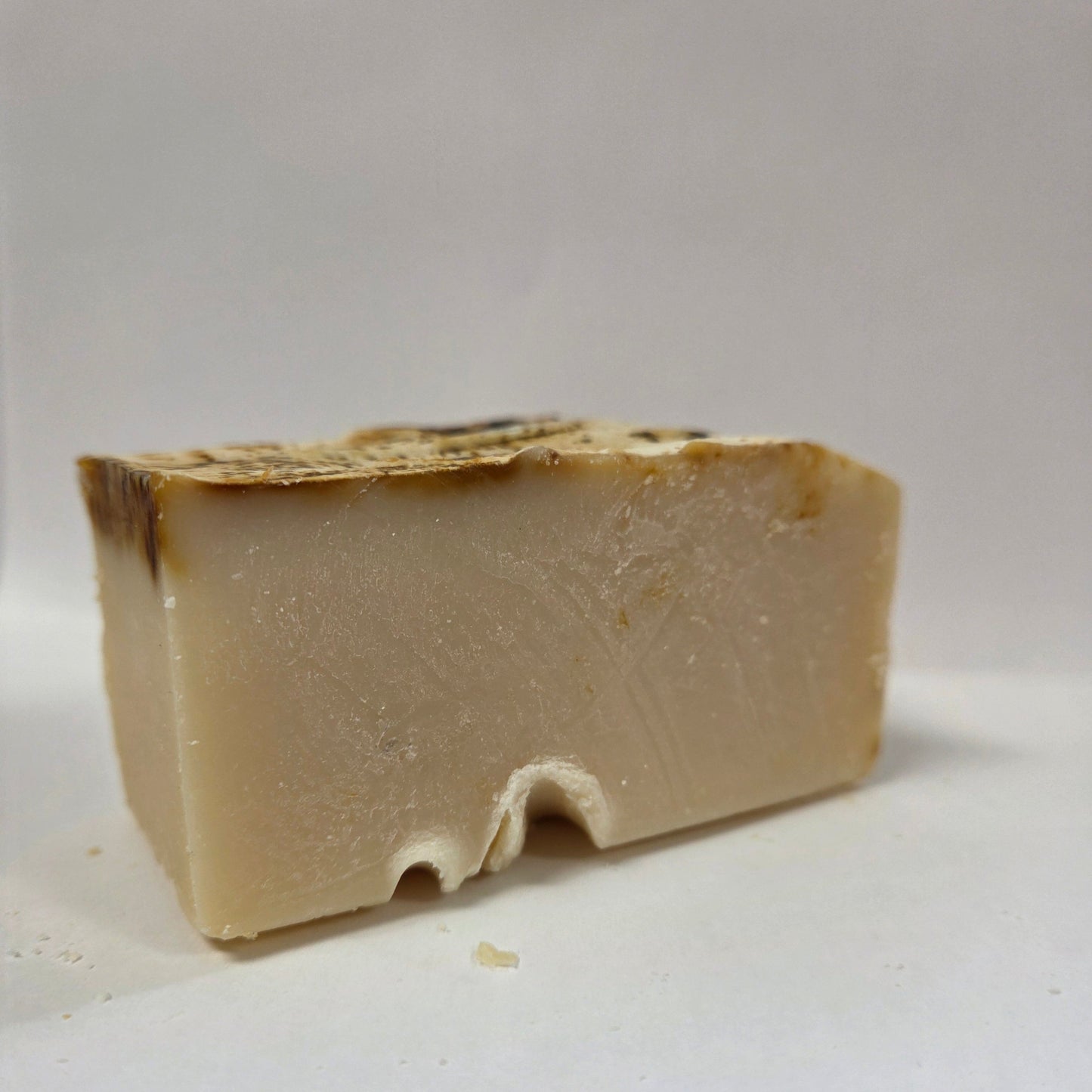 Block of beige goat milk soap on a white background