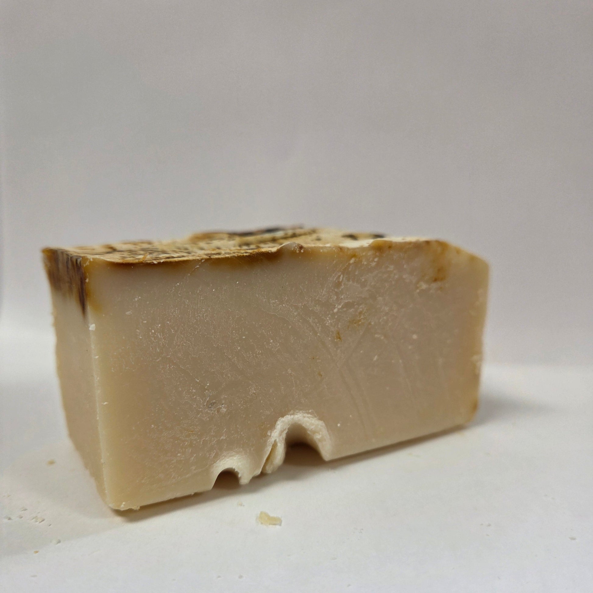 Block of beige goat milk soap on a white background