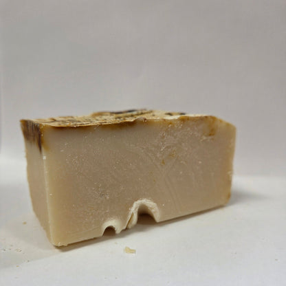 Block of beige goat milk soap on a white background