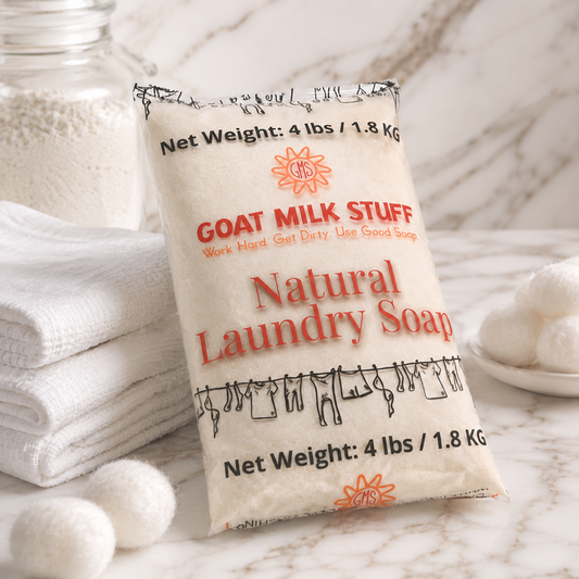 Bag of goat milk natural laundry soap with text on a marble surface with towels and soap bars.