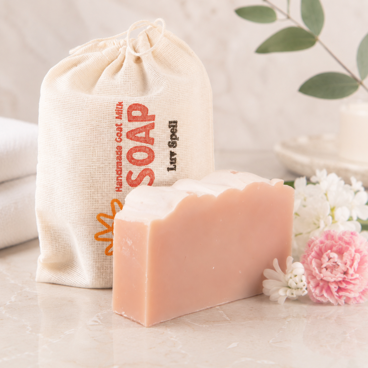Bar of soap with a drawstring bag labeled 'SOAP' on a light surface with flowers.
