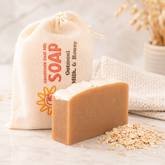 Bar of soap with oatmeal and a branded drawstring bag on a light background