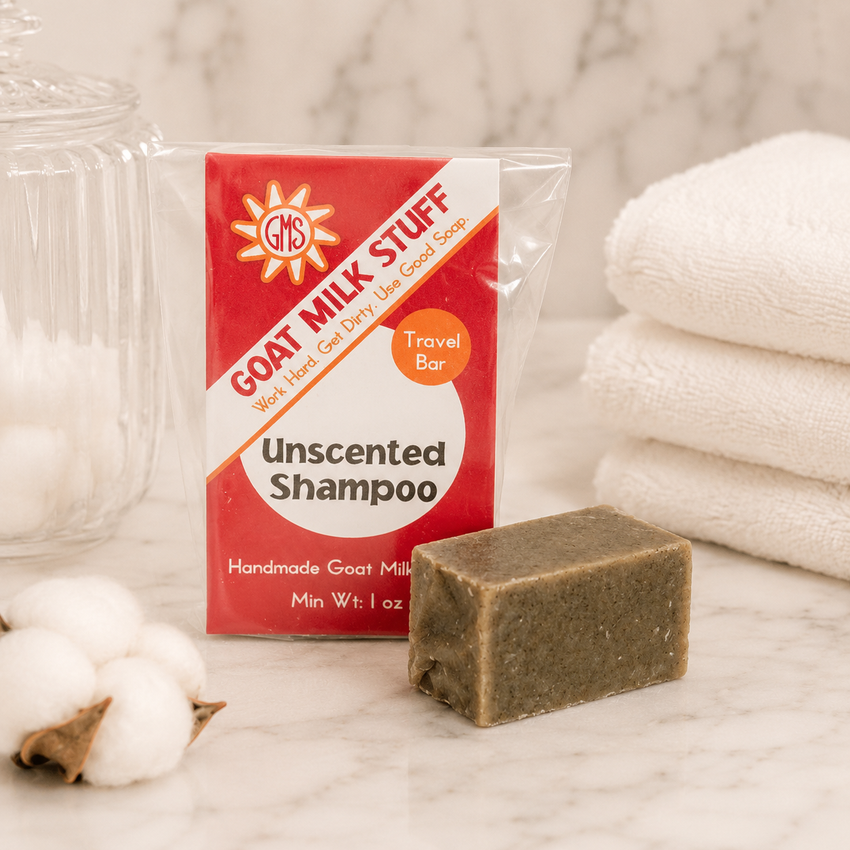 Goat Milk Stuff shampoo bar with packaging on a marble surface with cotton and towels.