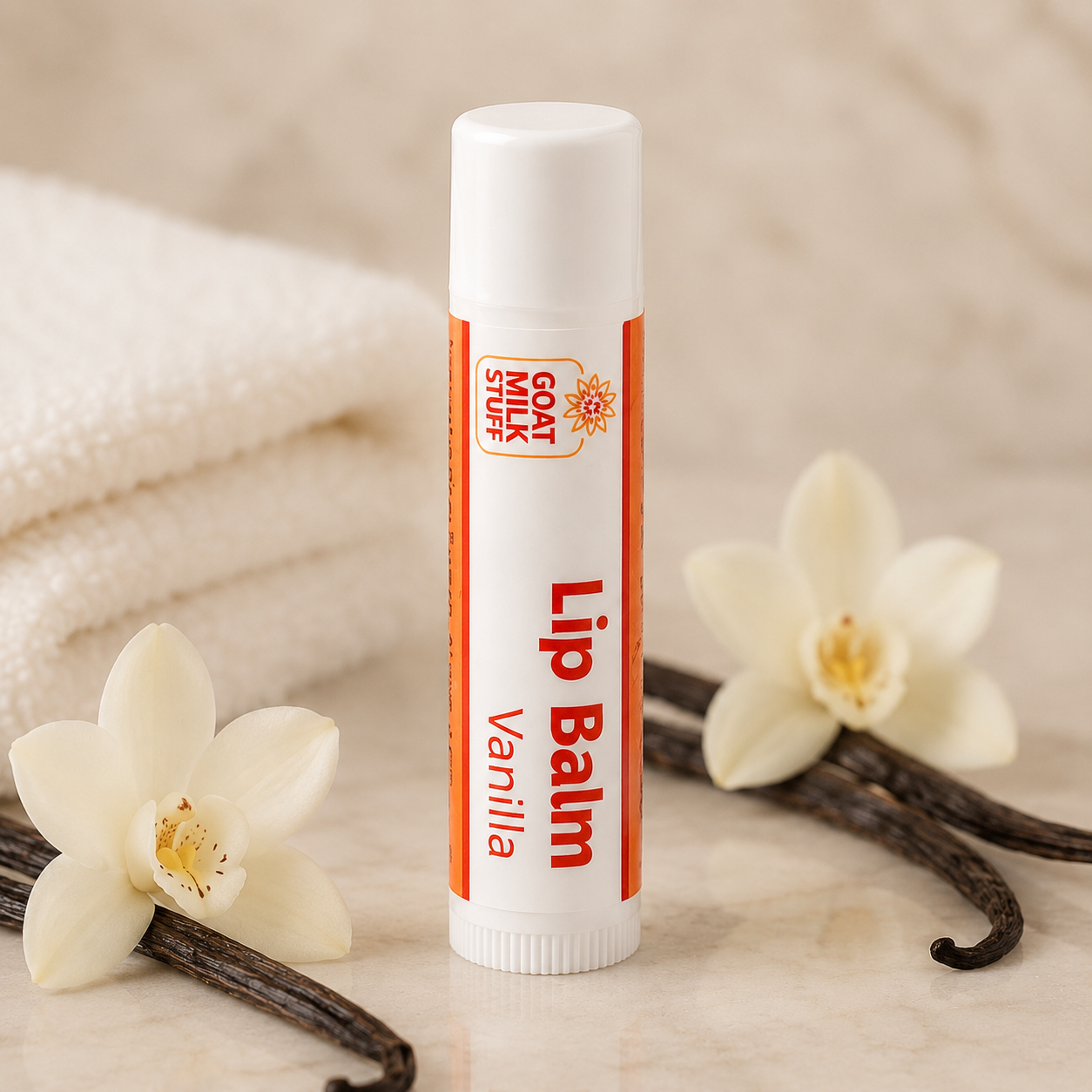 Lip balm with vanilla flavor on a marble surface with vanilla flowers and pods.