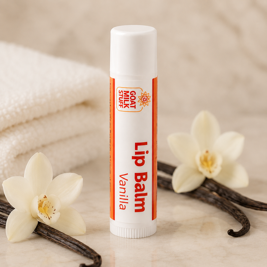 Lip balm with vanilla flavor on a marble surface with vanilla flowers and pods.