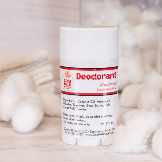 Goat Milk Stuff deodorant stick on a wooden surface with cotton balls in the background
